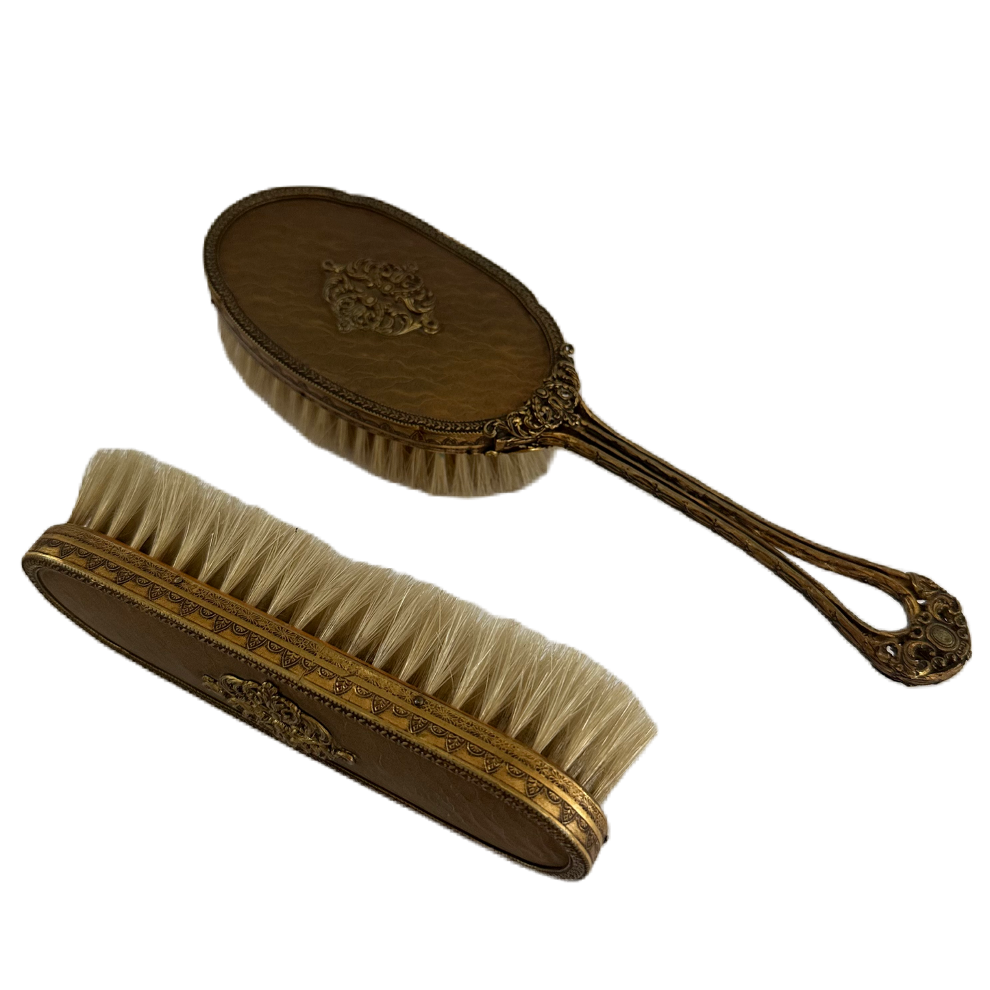 Set med två dekorativa och utsmyckade borstar i bronsfärg.