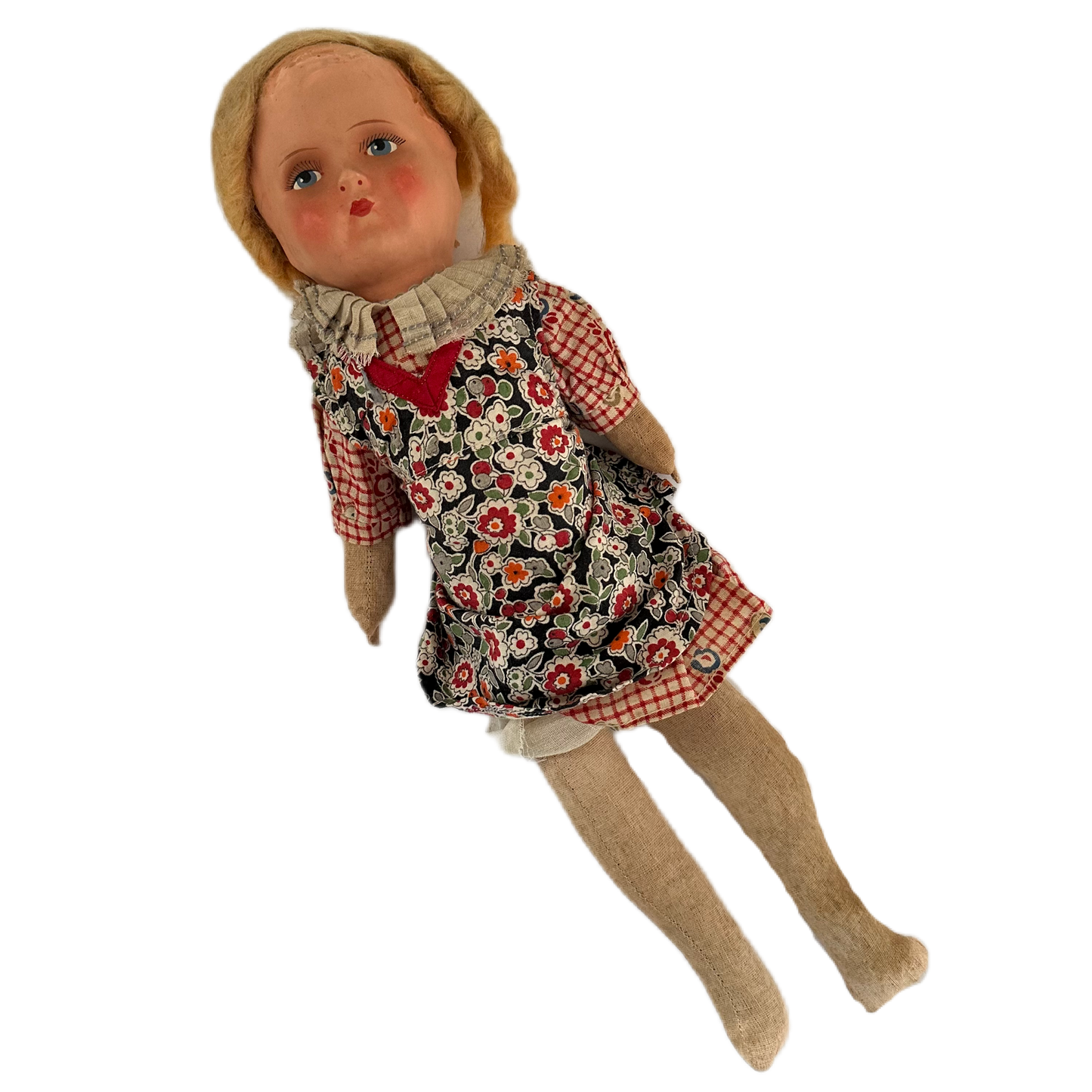 Docka med rutig klänning och blommigt förkläde. Huvud av celluloid och stoppad kropp i textil.