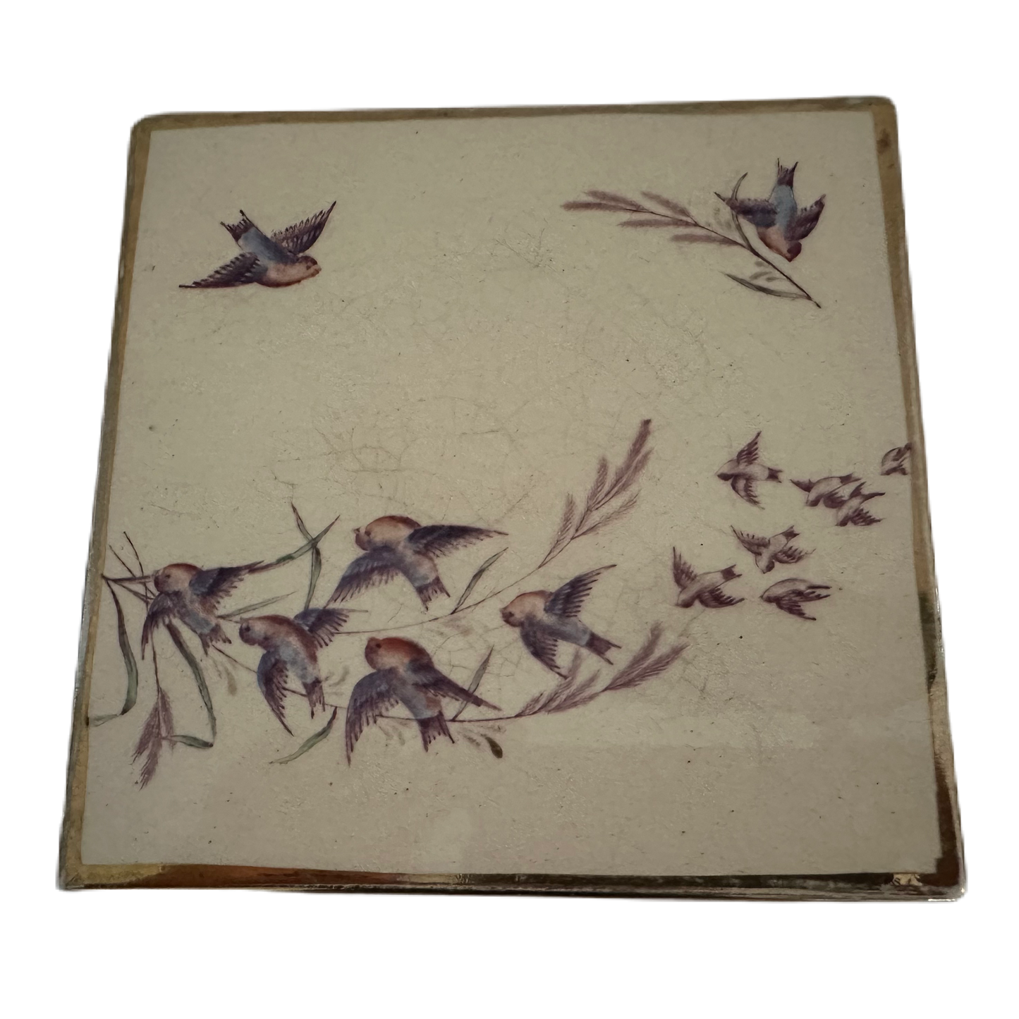 Dekorativt grytunderlägg från Rörstrand med motiv av fåglar mot vit bakgrund.