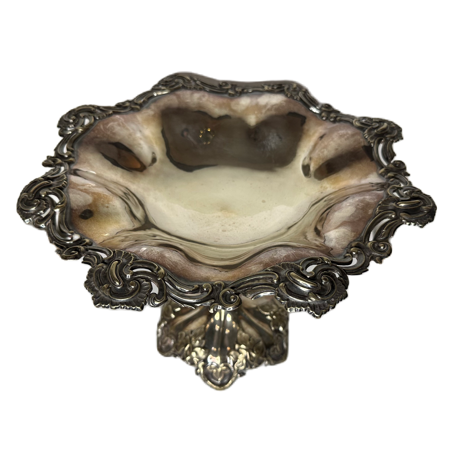 Ovansidan av en utsmyckad skål på fot i nysilver.