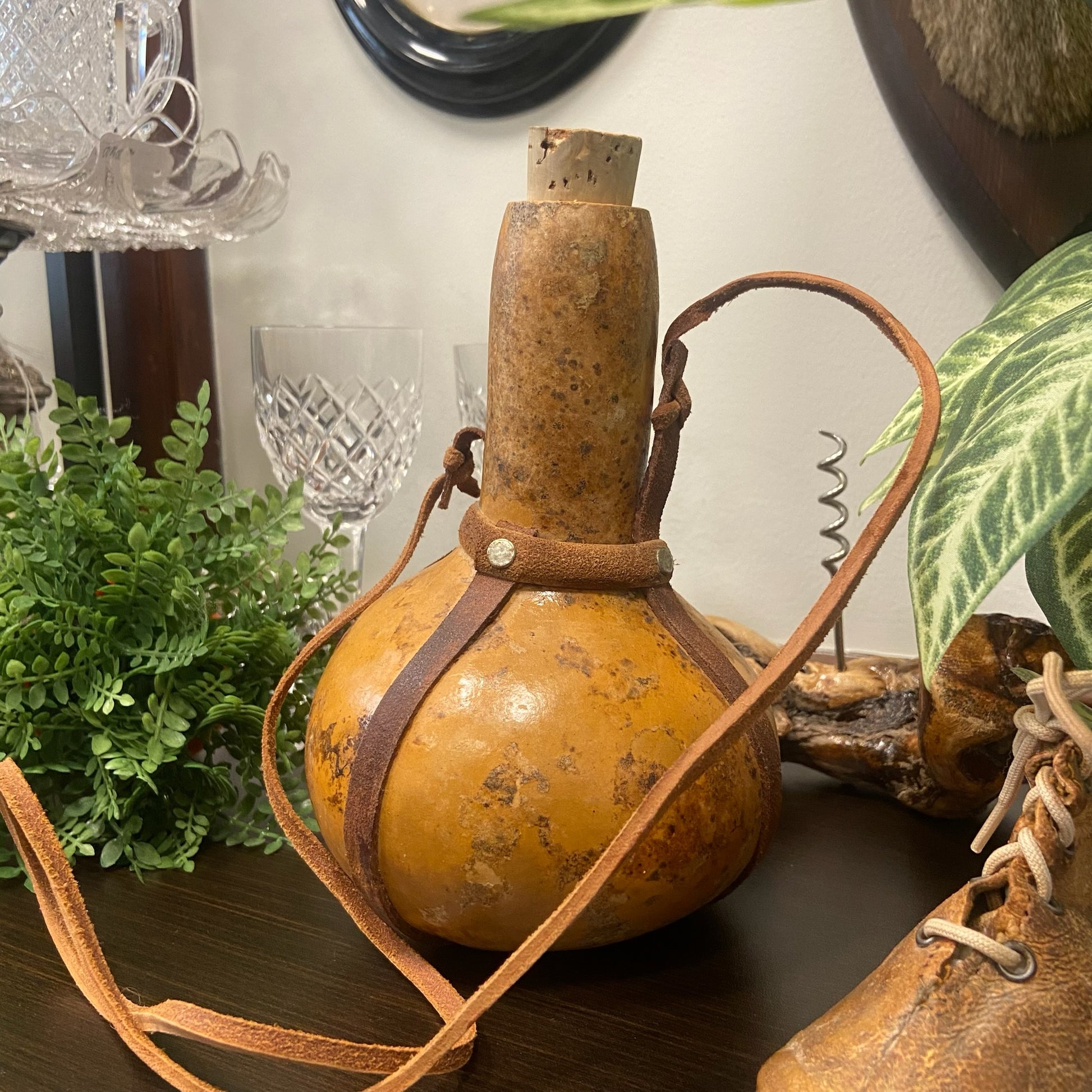 Behållare av kalebass med bärrem i läder.