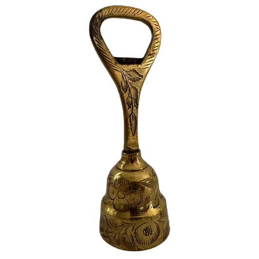 Mässingsfärgad bordsklocka med flasköppnare och dekor.