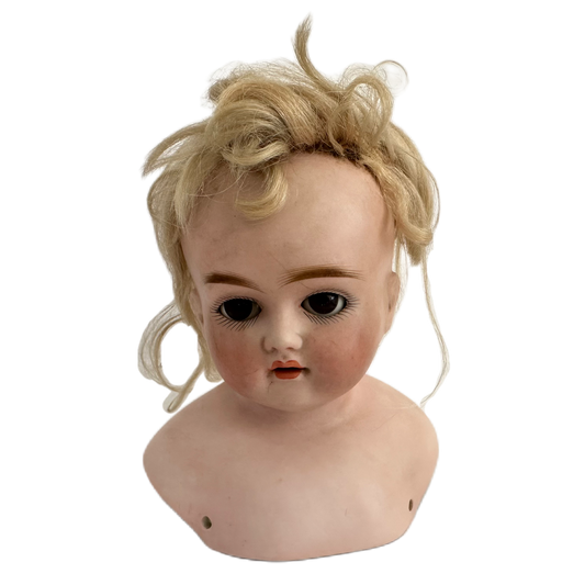 Dockhuvud i porslin med blont hår.