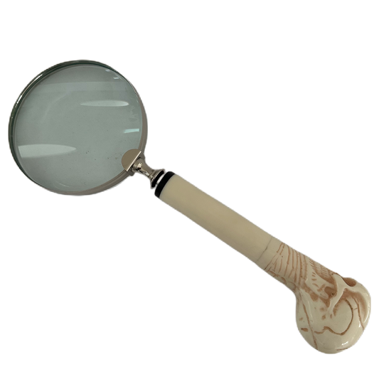 Förstoringsglas med vitt skaft i form av en dödskalle.
