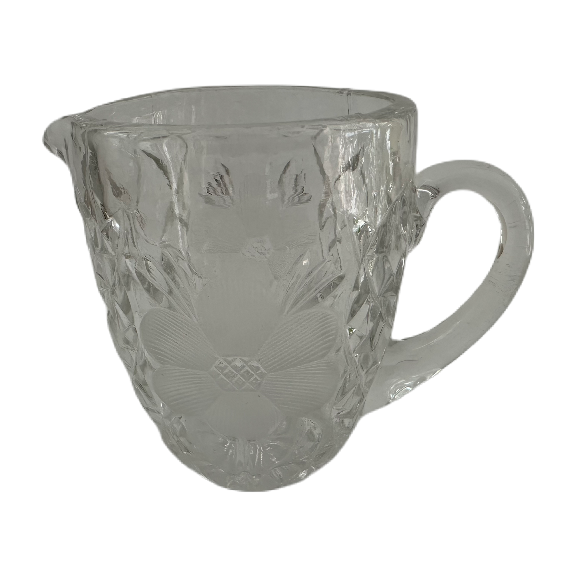 Gräddkanna i pressglas med slipad dekor och blommönster.