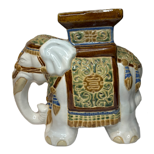 Piedestal i keramik föreställande en utsmyckad elefant.