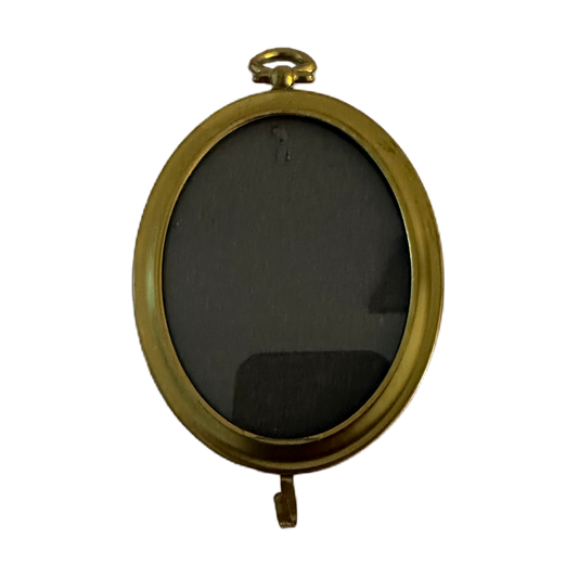 Liten, oval ram i guldfärg med krok.
