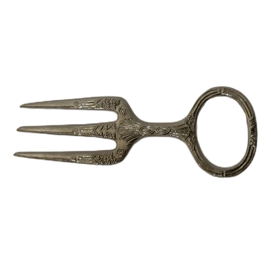 Silverfärgad skinkgaffel i metall med dekor.
