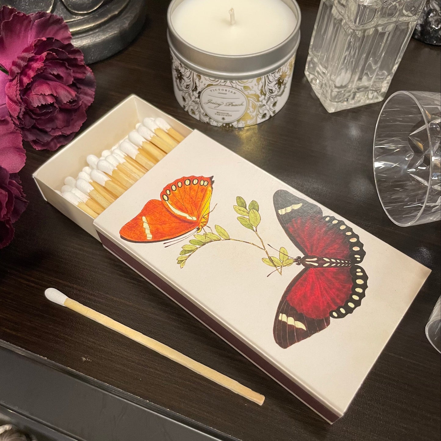 Tändsticksask med motiv av färgglada fjärilar innehållandes långa tändstickor från Sköna Ting.