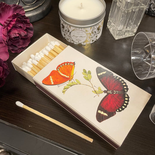 Tändsticksask med motiv av färgglada fjärilar innehållandes långa tändstickor från Sköna Ting.
