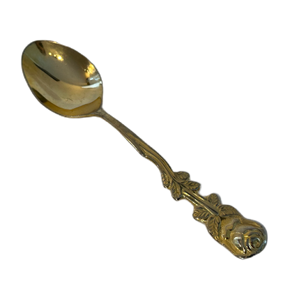 Guldfärgad tesked i rostfritt stål med dekorativ utsmyckning, föreställandes en ros.