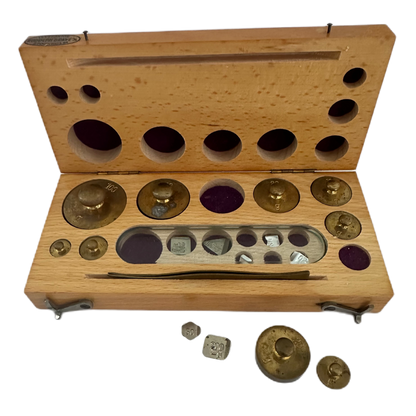 Viktsats i träetui innehållandes 16 vikter samt pincett.