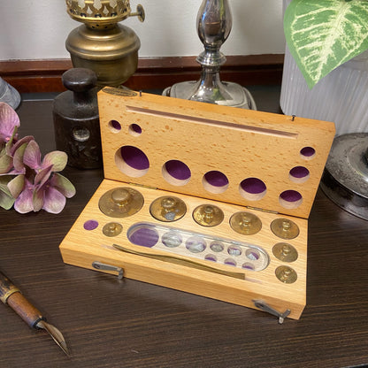 Viktsats i träetui innehållandes 16 vikter samt pincett.